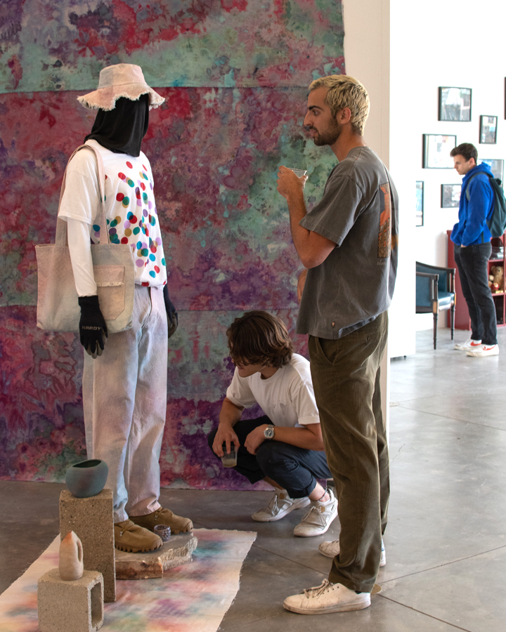 Gallery visitors look at artwork at the 2022 Fine Arts Senior Exhibition.
