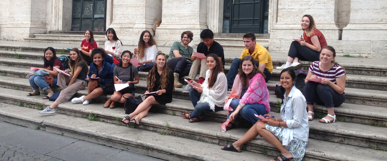 Students sitting outside on a trip abroad.
