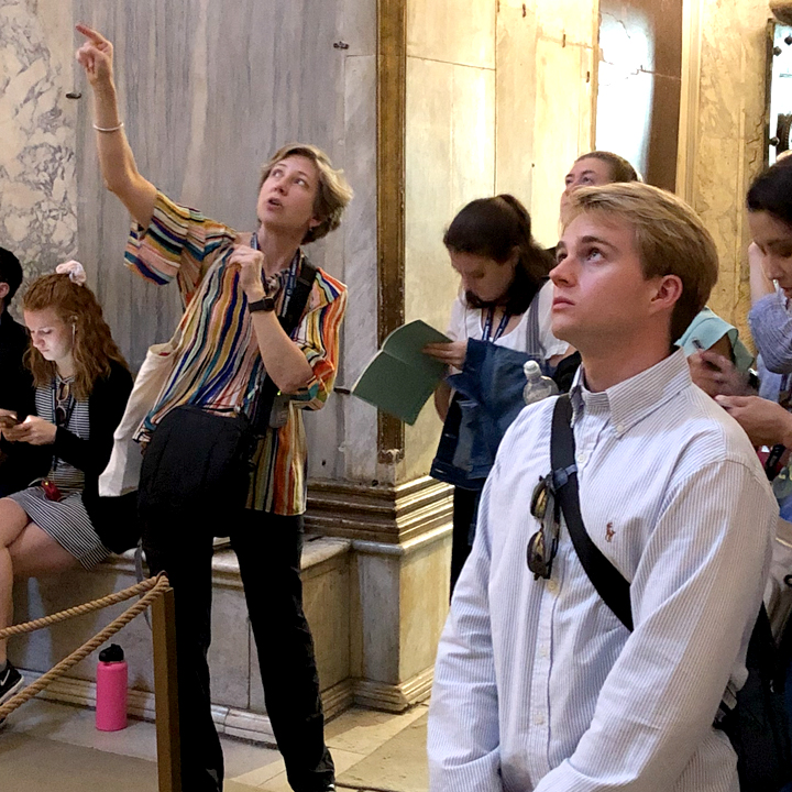 Professor Kirstin Noreen showing art to students during a trip.