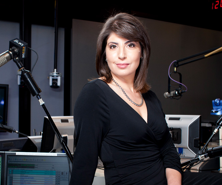 Claudine Cazian sitting on a desk at a radio station.