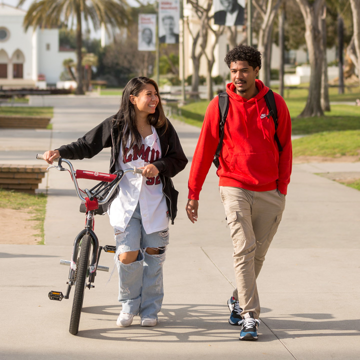 Two students walking around the alumni mall area.