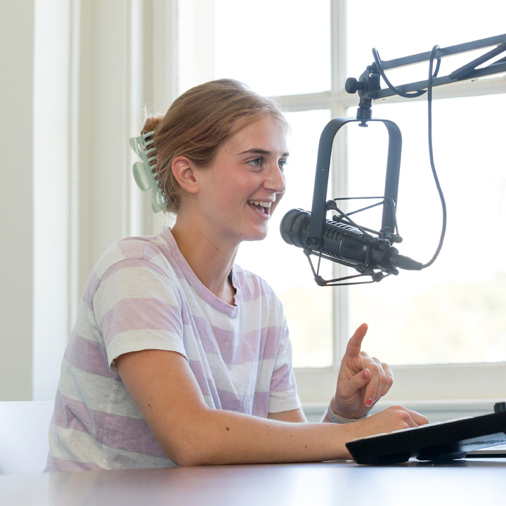 A student in the podcasting studio recording her next show.