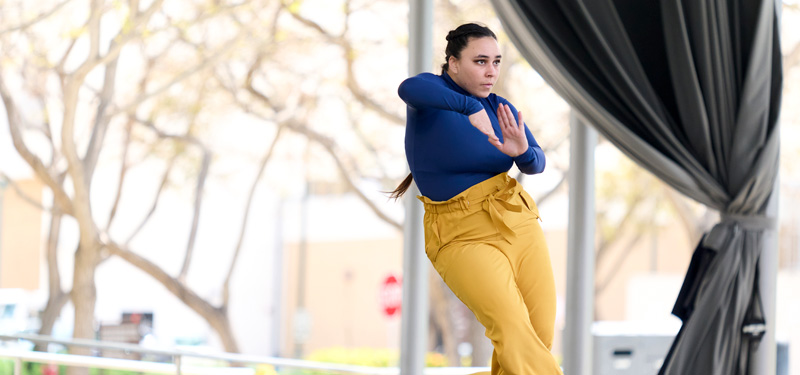 A dancer in blue performing on a sunny day at the Drollinger Family Stage.