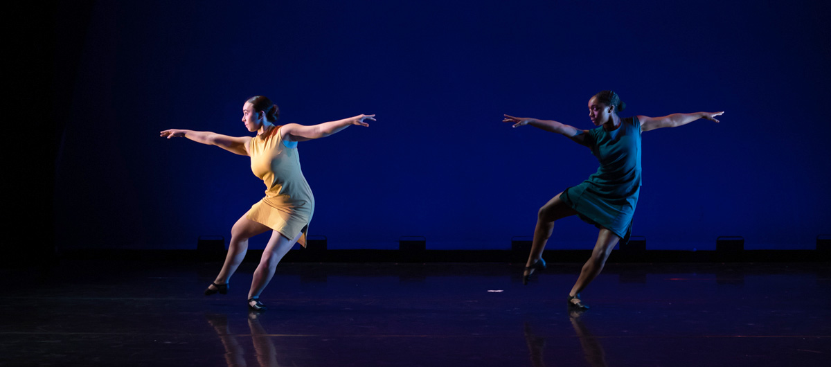 Two dancers performing side by side.