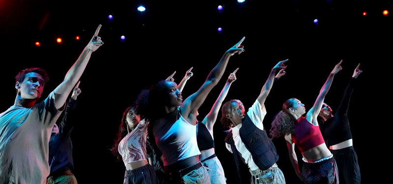 Dancers pointing upward during a performance.