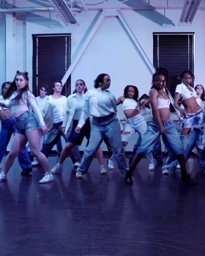 A large group of dancers performing in the dance studio.