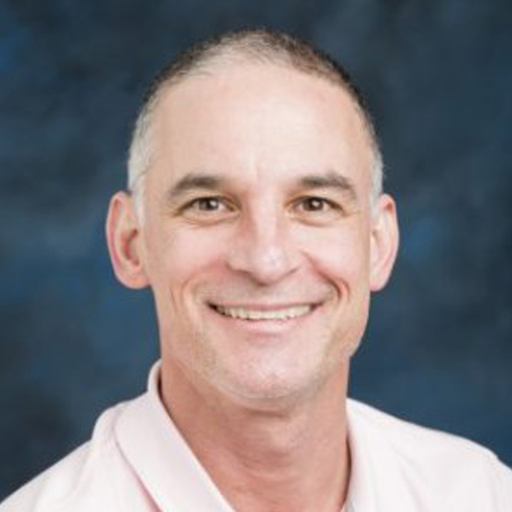 Headshot of Damon Rago in a light-colored shirt.