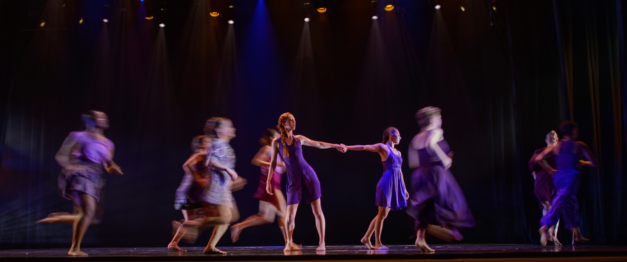 Two dancers in the center of a group at the Fall '15 Faculty Concert.