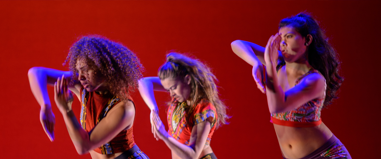 Three dancers perform in front of a red backdrop at the Spring '16 Student Concert.
