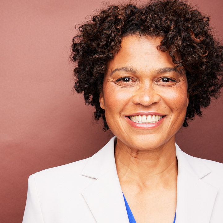 Photo of Roz LeBlanc in front of a red background.