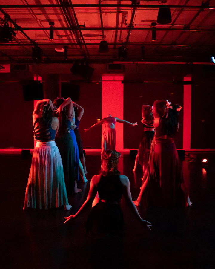 Dancers enveloped in red light.