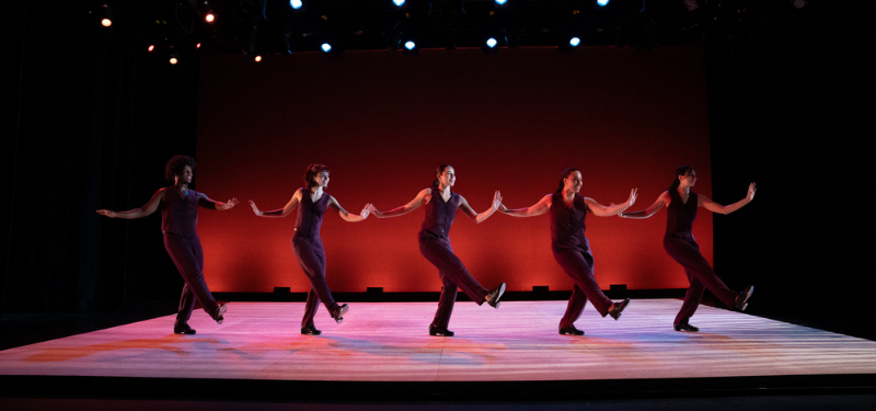 Five dancers doing the same move.