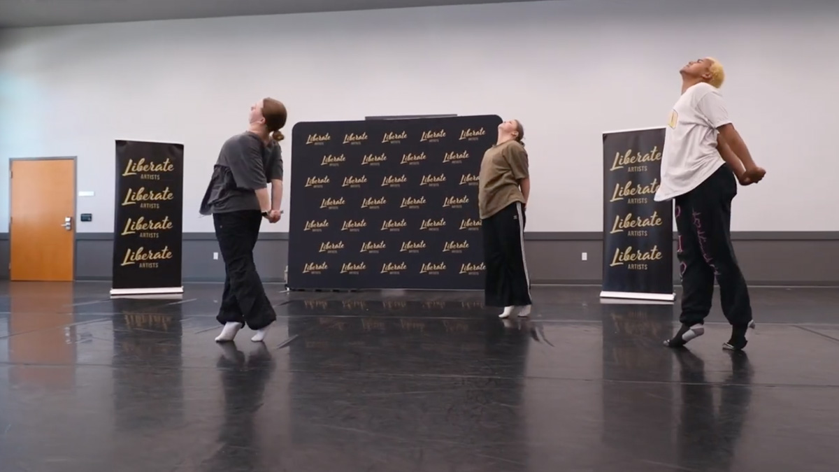 Three dancers performing in a studio.