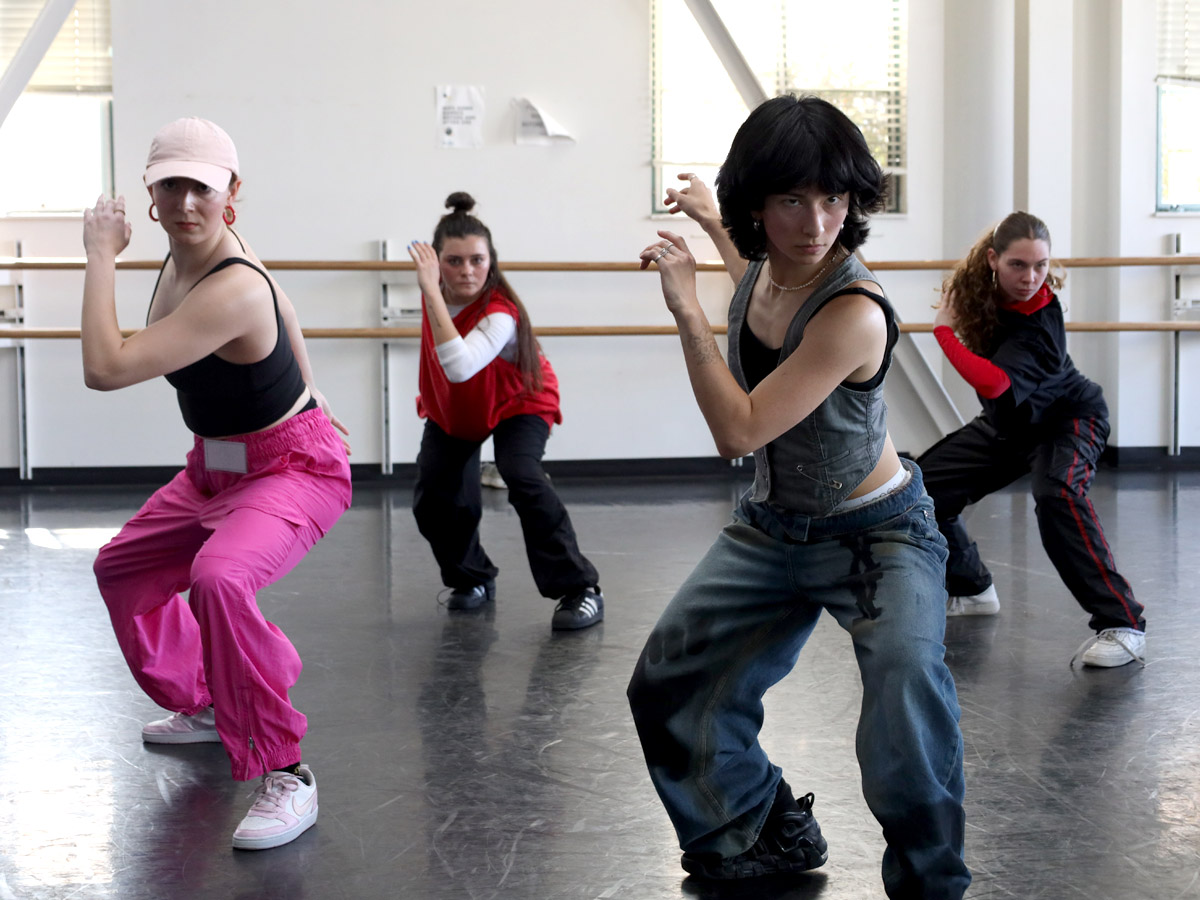 Four dancers performing in a studio.