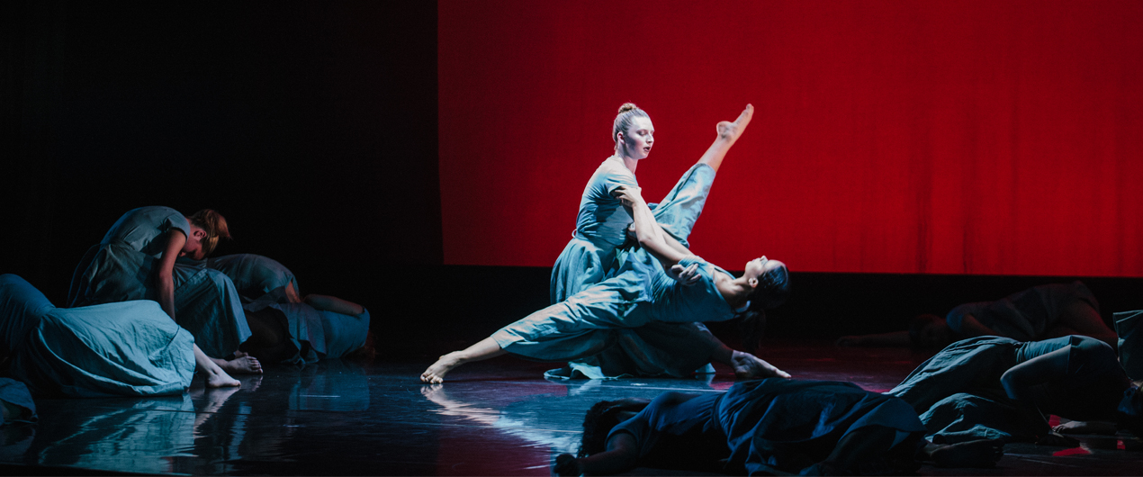 Dancers in front of a red backdrop in Fall '17 Faculty Concert.