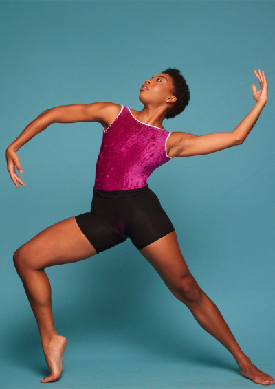 a woman posing with arms in the air and front knee bent