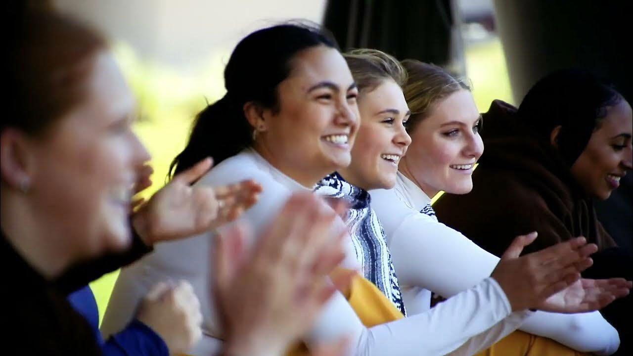 Dancers on stage holding and smiling at the end of a performance