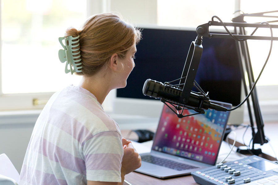 A student sitting at a desk with audio equipment.