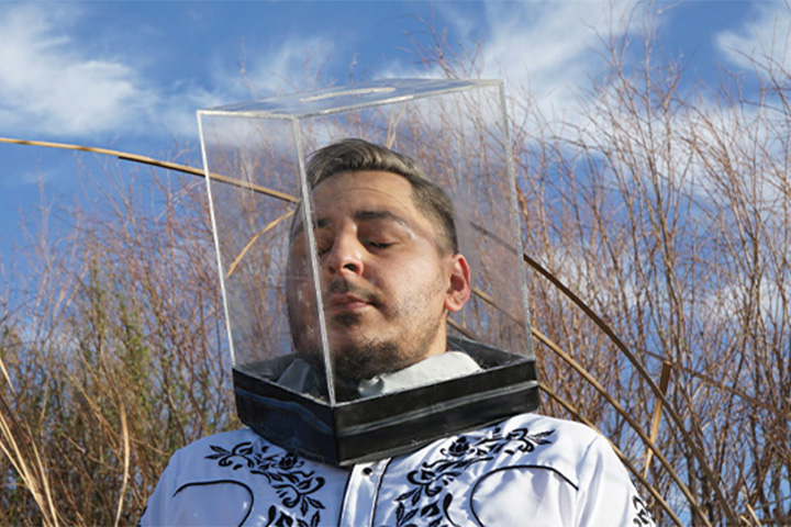 a man posing with a clear box on top of his head