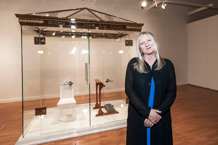 Artist standing next to her work at the Confess exhibition.