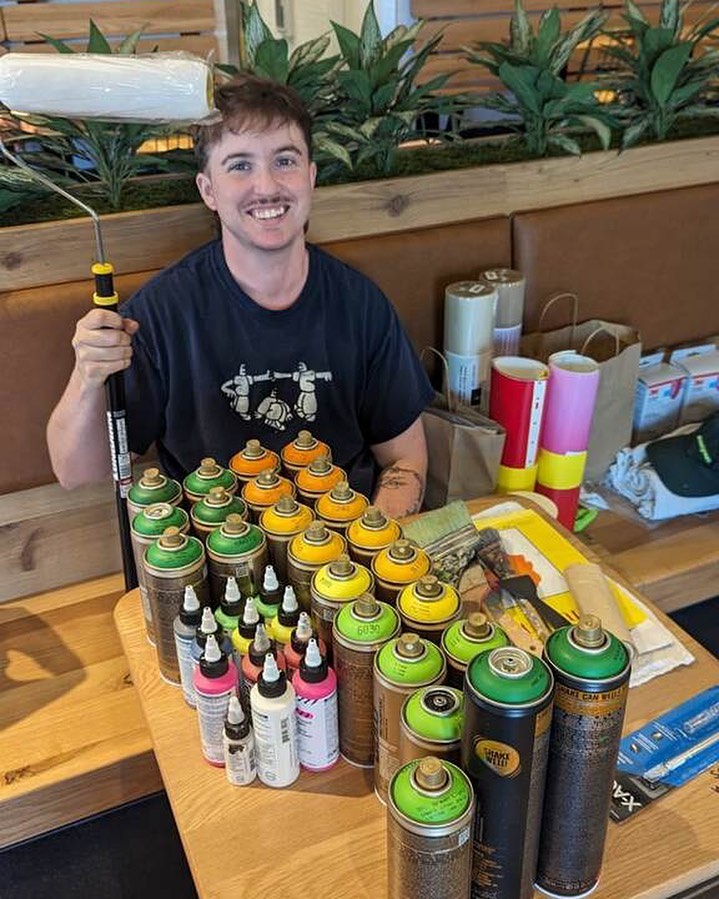 Photo of an artist with colorful paint and a roller