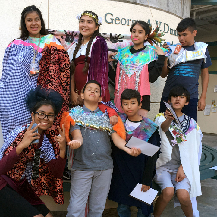 A group of students posing with their artwork in the Burns Courtyard.