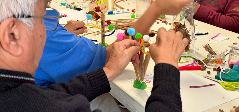 A group of people making art using a variety of materials.