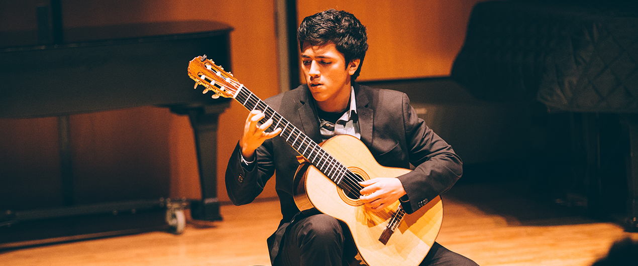 A young guitarist performs on stage