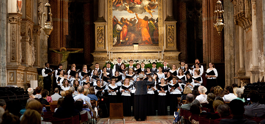 A large chorus performs in a European church