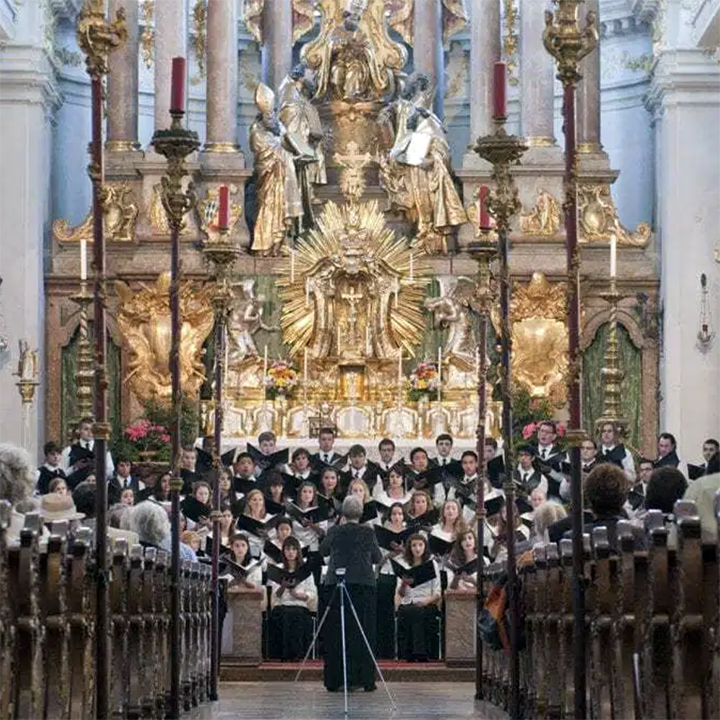 A large chorus performs in a European church