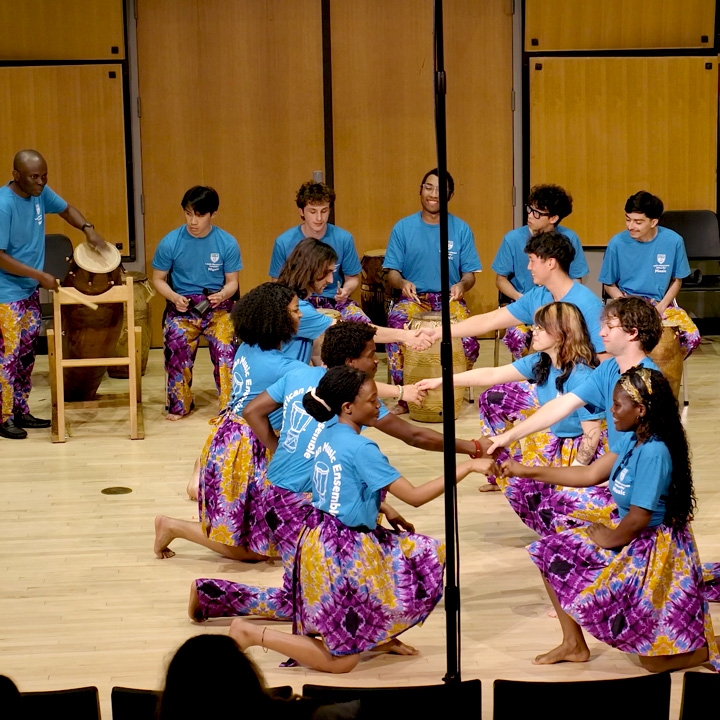 LMU African Music Ensemble performing in Murphy Recital Hall, wearing colorful outfits.