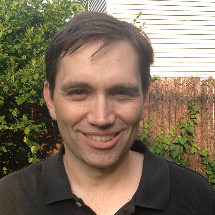 Photo of David Carter in a dark-colored shirt, standing outside with plants in the background.