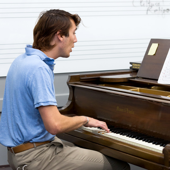 A student performing a song on the piano during class.