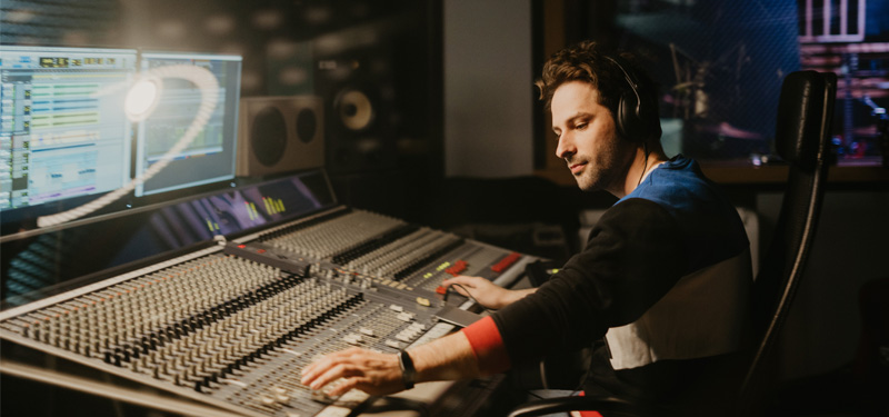 A man working on a sound mix in a studio.