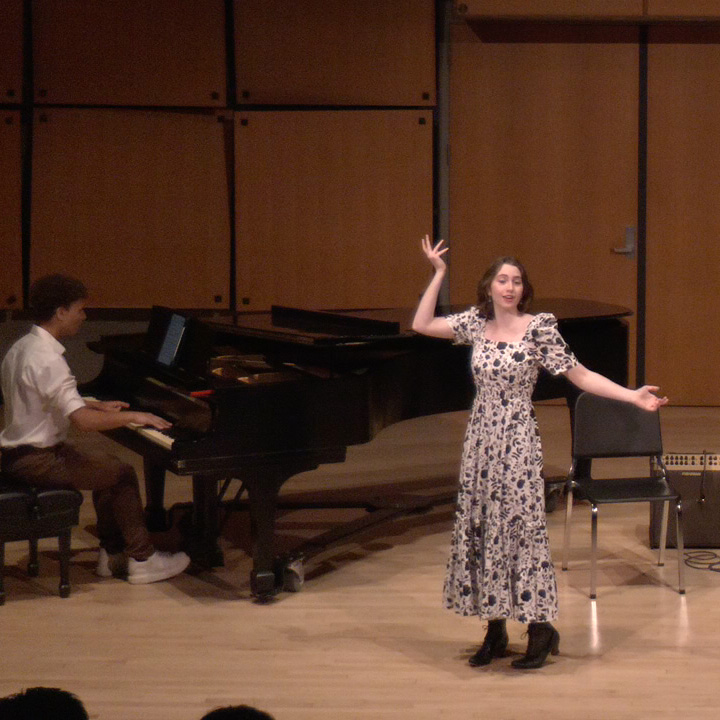 A singer performing in Murphy Recital Hall, accompanied by a pianist.