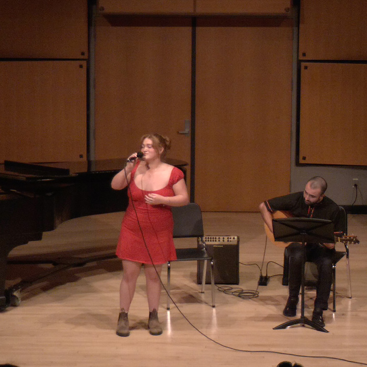 A singer performing in Murphy Recital Hall, accompanied by a guitarist.