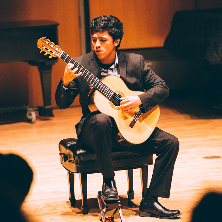 Photo of a student playing a guitar in Murphy Recital Hall.