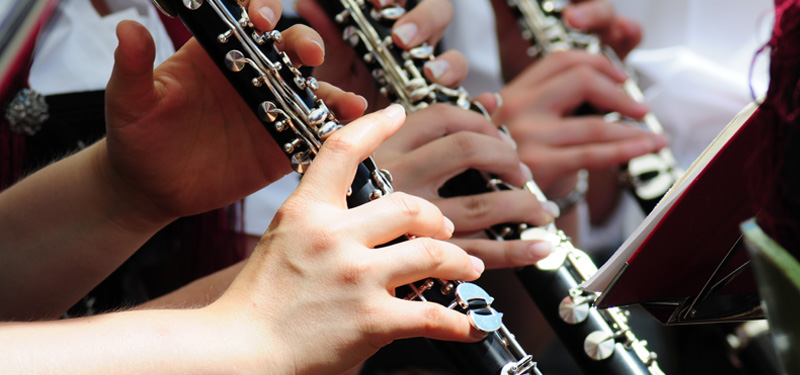 Close-up of people playing their clarinets.