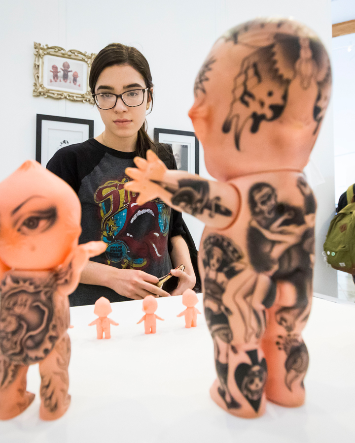 A gallery visitor looks at artwork at the 2018 Fine Arts Senior Thesis Exhibition.