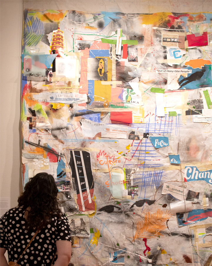A gallery visitor looks at artwork from the 2022 Graphic Design Senior Exhibition.