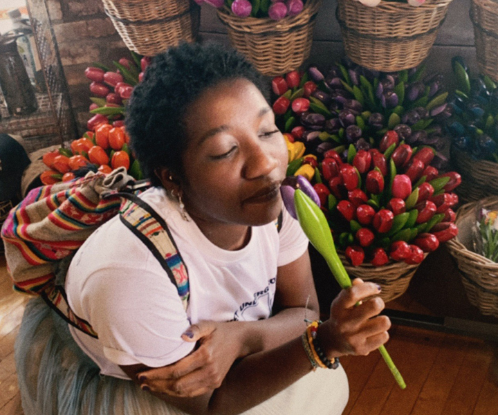 Photo of Fati Zulaikha smelling a flower.