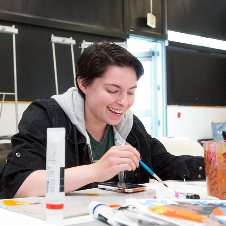 A student working on artwork in the Principles of Color class..