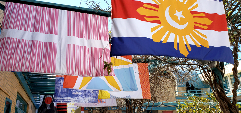 A series of flags, created by graphic design students, on display in the courtyard.
