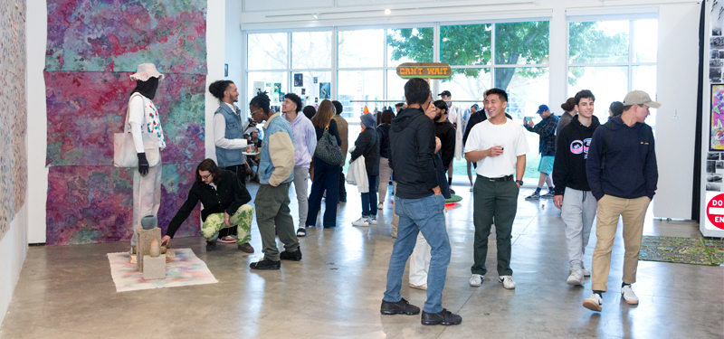 Gallery visitors exploring the 2022 Multimedia and Fine Arts Senior Exhibition.