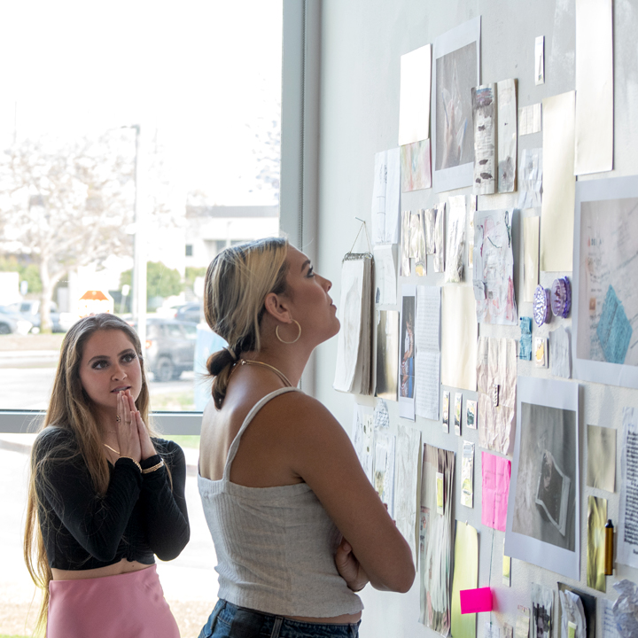 Students looking at artwork at the 2022 Fine Arts Senior Exhibition.