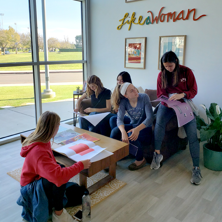 Gallery visitors looking at an exhibit at the 2019 Graphic Design Senior Exhibition.