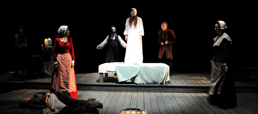 Performers in a scene from The Crucible.