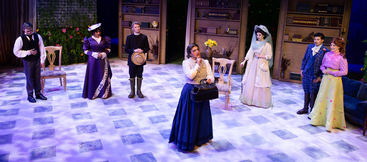 A group of people look on as a woman considers something.