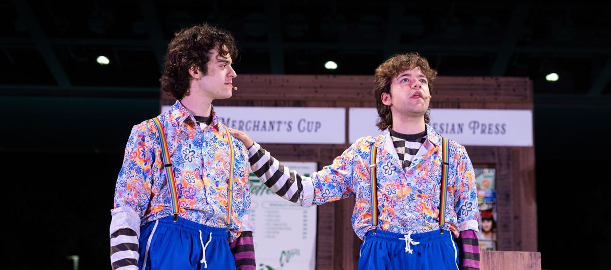 Two guys in identical outfits talking to each other.