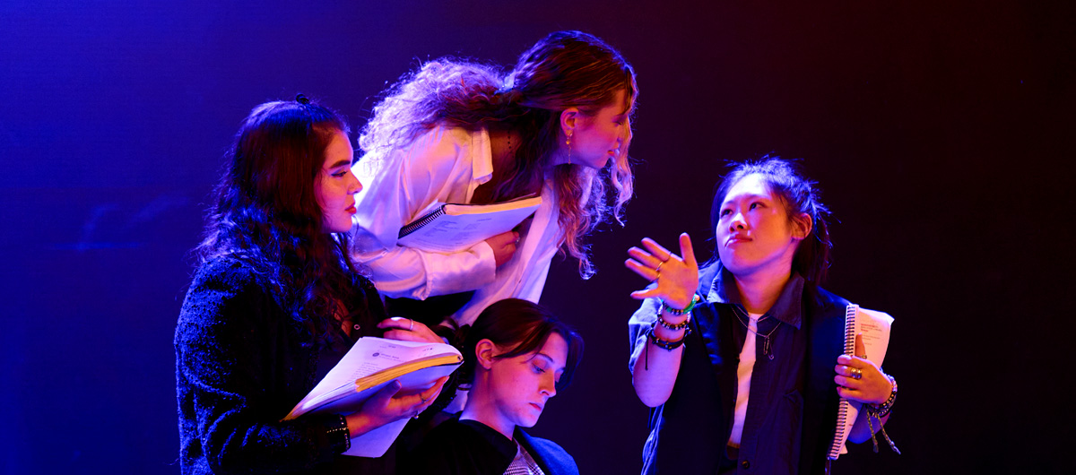 Four women conferring with each other.